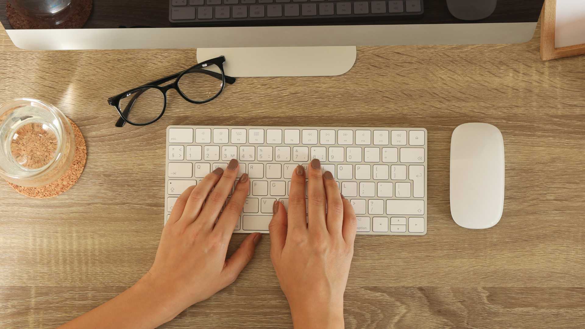 mains d'une femme qui tape à l'ordinateur